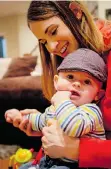  ?? JEFF MCINTOSH/THE CANADIAN PRESS ?? Meaghan Mikkelson-Reid, holds her son, Calder Reid, at their home in Calgary on Thursday. She’s back in action next week.