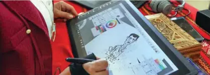  ??  ?? Syrian cartoonist Amani Al-Ali sketches a portrait of President Bashar al-Assad in her home studio.