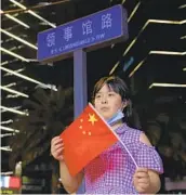  ?? NG HAN GUAN AP ?? A child displays a Chinese national flag as she poses Sunday for a photo outside the United States Consulate in Chengdu in southwest China.