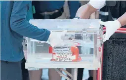  ?? DITA ALANGKARA/AP ?? Indonesian transporta­tion safety officials carry a box with Sriwijaya Air Flight 182’s flight data recorder, which was retrieved Tuesday from the Java Sea.