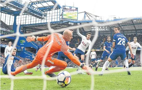  ?? Picture: Getty. ?? Dele Alli, centre, squeezes his shot past Chelsea keeper Willy Caballero to make it 3-1 for Spurs.