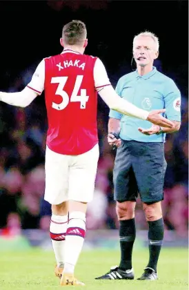  ??  ?? Arsenal’s Granit Xhaka speaks to referee Martin Atkinson during the English Premier League match at the Emirates Stadium, London, Sunday, October 27, 2019.