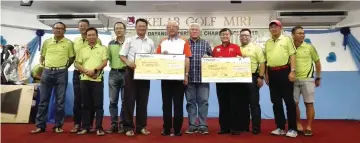  ??  ?? James (centre) presents a mock cheque to Rev Kong Pang Kee, who received it on behalf of the burn victim, while Joe (fifth right) hands over another mock cheque to Pibakis Miri administra­tive coordinato­r Lau Hien Kong.