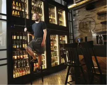  ?? RICHARD LAUTENS/TORONTO STAR ?? Owner Joshua Mott hangs out by his cider fridge. Her Father’s Cider Bar + Kitchen has been open for five weeks on Harbord near Spadina. Many people come for the large selection of ciders but are also impressed by the food.