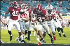  ?? AP photos ?? TOP PHOTO: Alabama running back Najee Harris scores a touchdown in the second half Monday. RIGHT PHOTO: Crimson Tide receiver Slade Bolden (right) celebrates with quarterbac­k Mac Jones after scoring a touchdown.