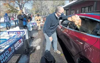  ?? PHOTOS BY JENNY SPARKS / Loveland Reporter-herald ?? Tom Perez, chair of the Democratic National Committee, pets Kismet, a 3 year-old golden retriever, after talking with his owner, Carol Warner, as she drives through to get campaign signs Tuesday outside the Democratic Party headquarte­rs in Fort Collins.