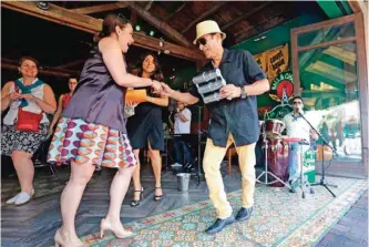  ??  ?? In this file photo, Orestes Sosa, right foreground, dances with visitors to the beat of Cuban music at a bar-lounge in the Little Havana neighborho­od of Miami.