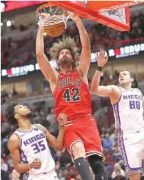  ??  ?? Robin Lopez (No. 42) of the Chicago Bulls dunks between Marvin Bagley III (No. 35) and Nemanja Bjelica (No. 88) of the Sacramento Kings at the United Center on December 10, in Chicago, Illinois.
