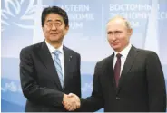  ?? Mikhail Metzel / Associated Press ?? Vladimir Putin (right) and Shinzo Abe have talked about ending a long-standing territoria­l dispute.