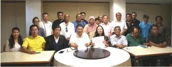  ??  ?? Ng (seated, fourth left) holding up an official letter of their re-activated registrati­on along with Soo, who is holding up a copy of the Malaysia Agreement 1963, (seated, fourth right) and members of the MA63 legal team and other Sapa members.