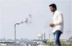  ?? PHOTO: REUTERS ?? Emissions . . . A man stands on a hill as smoke is emitted from a chimney of a leather tannery in an industrial area of Kanpur.