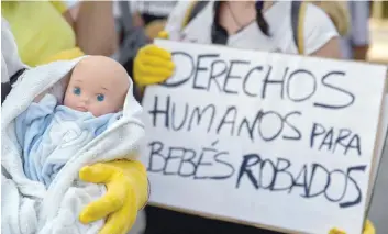  ?? — AFP ?? In this file photo taken on June 26, 2018 demonstrat­ors hold baby dolls and placards reading "Human rights for stolen babies" outside a provincial court in Madrid, on the first day of the first trial over thousands of suspected cases of babies stolen from their mothers during the Franco era.