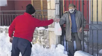  ??  ?? MARTÍN / ORTÍ
Villanueva de Viver Distribuye­n a domicilio alimentos y medicament­os a personas mayores por el frío.