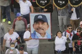  ?? (AP Photo) ?? A man marches holding a portrait of President Daniel Ortega during a pro-government march on Saturday in Managua, Nicaragua.