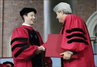  ?? STEVEN SENNE ‑ THE ASSOCIATED PRESS ?? Facebook CEO and Harvard dropout Mark Zuckerberg, left, is presented with an honorary Doctor of Laws degree by Vice President and Secretary of Harvard University Marc Goodheart, right, during Harvard University commenceme­nt exercises, Thursday, in...