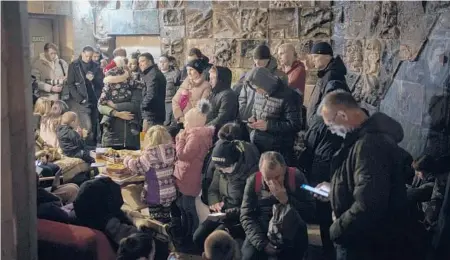  ?? ?? People take refuge in a basement that is being used as a bomb shelter on Saturday in Lviv, Ukraine.