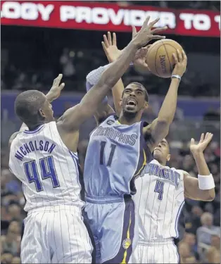  ?? JOHN RAOUX/ASSOCIATED PRESS ?? “Our pace is what made the difference,” said Griz point guard Mike Conley, above shooting between Orlando’s Andrew Nicholson (44) and Arron Afflalo during the first half of Sunday’s easy win.