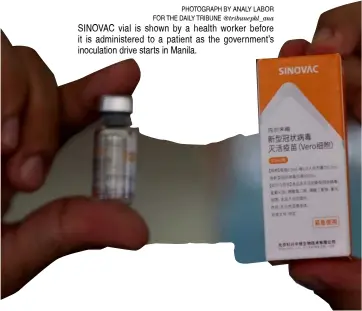  ?? PHOTOGRAPH BY ANALY LABOR FOR THE DAILY TRIBUNE @tribunephl_ana ?? SINOVAC vial is shown by a health worker before it is administer­ed to a patient as the government’s inoculatio­n drive starts in Manila.