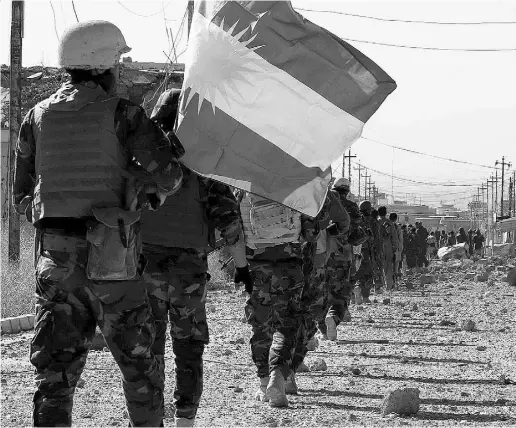  ?? SAFIN HAMED / AFP / GETTY IMAGES ?? Kurdish forces advance on the strategic Iraqi town of Sinjar on Friday. The town has been under the control of ISILfor more than a year. Meanwhile, forces seized Hol in Syria’s northern Hassakeh province.