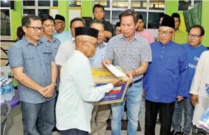  ??  ?? LIMUS mengagihka­n sumbangan beliau serta sumbangan daripada Skuad Sayang Sabah.