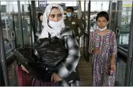  ?? JOSE LUIS MAGANA—ASSOCIATED PRESS ?? Families evacuated from Kabul, Afghanista­n, walk through the terminal before boarding a bus after they arrived at Washington Dulles Internatio­nal Airport, in Chantilly, Va., on Friday, Aug. 27, 2021.