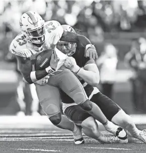  ?? BRIAN FLUHARTY/USA TODAY SPORTS ?? Patriots linebacker Jahlani Tavai (48) tackles Dolphins running back Jeff Wilson Jr. (23) on Jan. 1 at Gillette Stadium.