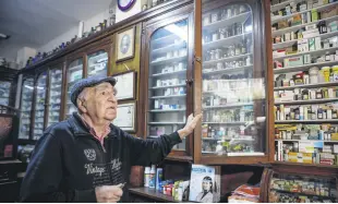  ?? ?? Melih Ziya Sezer shows the shelves filled with modern and ancient medicines at the pharmacy, in Istanbul, Turkey, Dec. 10, 2021.