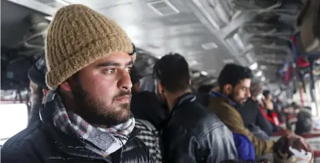  ?? — AFP photos ?? Reyaz (le ) stands in a crowded carriage of a passenger train on his way back to Kashmir from Banihal.