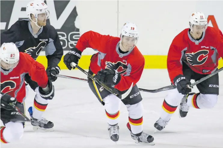  ?? — GAVIN YOUNG ?? From left, Michael Frolik, Dougie Hamilton Matthew Tkachuk and Mikael Backlund practise ahead of their quarter-final series against the Ducks.