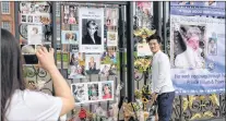  ?? AP FILE PHOTO ?? A tourist takes a photo with her smartphone, as a friend poses next to tributes and memorabili­a for the late Diana, Princess of Wales outside Kensington Palace in London. The tributes are placed on one of the ornamental gates at the palace ahead of the...