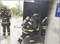  ?? Contribute­d photo / ?? Firefighte­rs enter a building during live burn training.