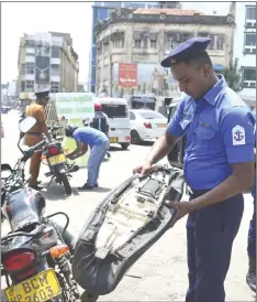  ??  ?? Sri Lankan Navy personnel inspect a motorcycle as they block a road at the harbour in Colombo, after a series of bomb blasts targeting churches and luxury hotels on Easter Sunday in Sri Lanka. — AFP photo