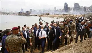  ?? (Photo EPA) ?? Image saisissant­e du chef de l’Etat avec en arrière-plan le port de Beyrouth entièremen­t dévasté par le souffle de la double explosion de mardi soir.