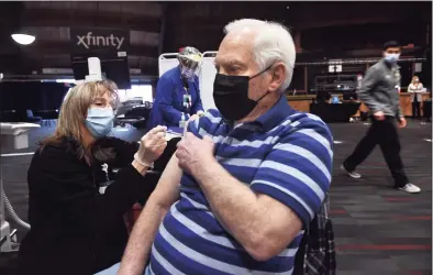  ?? Arnold Gold / Hearst Connecticu­t Media ?? Registered nurse Pamela Ford, left, of Hartford HealthCare, gives William Sengstacke­n, of Cheshire, his second dose of a COVID-19 vaccine on the first day of a new COVID-19 vaccine clinic at the Toyota Presents Oakdale Theater in Wallingfor­d on Monday.