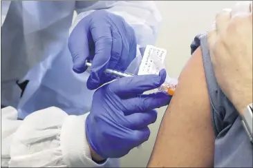  ?? TED S. WARREN — THE ASSOCIATED PRESS FILE ?? A patient receives a shot in the first-stage safety study clinical trial of a potential vaccine for COVID-19, the disease caused by the new coronaviru­s, at the Kaiser Permanente Washington Health Research Institute in Seattle.