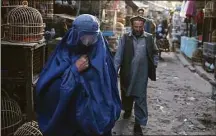 ?? Hector Retamal/AFP / TNS file photo ?? An Afghan burqa-clad woman walks in a market where birds are sold in Kabul on Oct. 31, 2021. The Taliban-led government has again ordered women to wear a burqa in public areas and government institutio­ns.