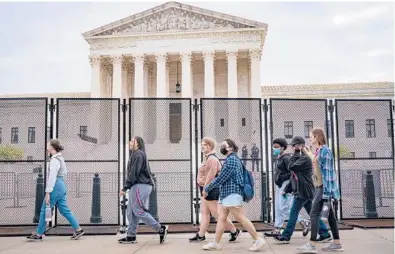  ?? PETE MAROVICH/THE NEW YORK TIMES ?? High school students pass a fence around the Supreme Court building last week in Washington.