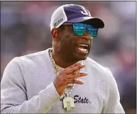  ?? Rogelio V. Solis / Associated Press ?? Jackson State head coach Deion Sanders calls out to his players who were warming up for the Southweste­rn Athletic Conference championsh­ip game against Southern on Saturday in Jackson, Miss. Sanders is taking over as coach at Colorado, bringing his charisma and larger-than-life persona to a beleaguere­d Pac-12 program that’s plunged to the bottom of college football.