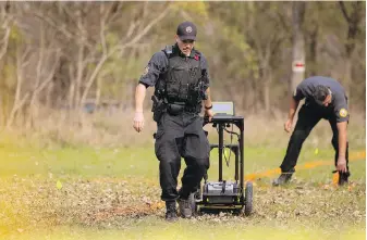  ?? CP FILE ?? Members of the Six Nations Police conduct a search for unmarked graves using ground-penetratin­g radar on 500 acres of land associated with the former Mohawk Institute Residentia­l School, in Brantford, Ont., on Nov. 9, 2021.