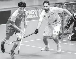  ??  ?? Singapore’s Sean Huang, left, and the Philippine­s’ Christofer Holland duel for possession during preliminar­ies of the floorball competitio­n in the 30th SEA Games at the UP College of Human Kinetics gym in Diliman, Quezon City. Singapore won 5-2. (Rio Deluvio)