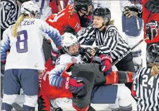  ?? AP PHOTO/JULIO CORTEZ ?? Official Jenni Heikkinen (64), of Finland, tries to separate Kelly Pannek (12), of the United States, and Laura Stacey (7), of Canada, as they scuffle during the third period of a preliminar­y round during a women’s hockey game at the 2018 Winter...