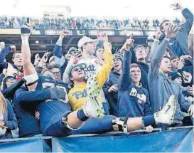  ?? [AP PHOTO] ?? Pittsburgh offensive lineman Brian O’Neill (70) and wide receiver Quadree Henderson (10) celebrate with fans in the student section after defeating Miami in an NCAA college football game Friday in Pittsburgh.