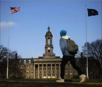  ?? Matt Rourke/Associated Press ?? A student walks in front of the Old Main building on Penn State University’s main campus in State College. A survey found college students want a return to face-to-face instructio­n in the fall, but 1,130 faculty signers of a letter want to be allowed to decide where and how to conduct classes to ensure safety.