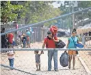  ??  ?? Gribil Mejia Tinoco of Santa Barbara, Honduras, leaves a shelter with his wife, Heidi, and their children after getting permission to temporaril­y stay in Mexico.