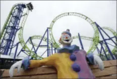  ?? JULIO CORTEZ — THE ASSOCIATED PRESS ?? In this photo, a statue of a clown rests on a bench as people riding the Hydrus roller coaster go over a drop at Casino Pier in Seaside Heights, N.J. More than four years after Superstorm Sandy destroyed part of the Casino Pier and left the...