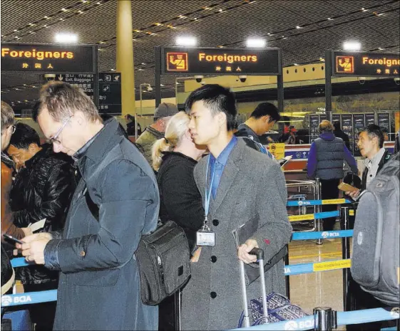  ?? NICOLE RAZ/LAS VEGAS REVIEW-JOURNAL ?? Foreign visitors to Beijing use English-language signage Nov. 29 to navigate around the Beijing Capital Internatio­nal Airport. Las Vegas tourism officials are hoping for a wave of nonstop flights, starting with Hainan Airlines, from China to Las Vegas...