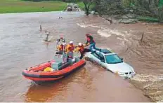  ?? AP ?? Firefighte­rs rescue a motorist as a flash flood washed over a road near Folsom on March 22. A powerful storm spread rain across California, swelling rivers and flooding streets.