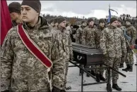  ?? EMILE DUCKE/THE NEW YORK TIMES ?? Ukrainian soldiers at a funeral in February in Irpin pay tribute to their fallen comrade, Eduard Strauss, killed in fighting near Bakhmut.