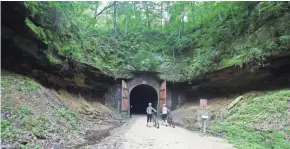  ?? CHELSEY LEWIS/MILWAUKEE JOURNAL SENTINEL ?? A pair of cyclists prepare to walk through Tunnel 1 on the Elroy-Sparta Trail.