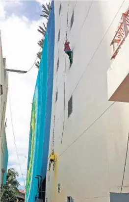  ?? HALLANDALE BEACH FIRE RESCUE/COURTESY ?? Two mural painters hang from the harnesses that saved their lives at the Hyde Resort & Residences on Monday.